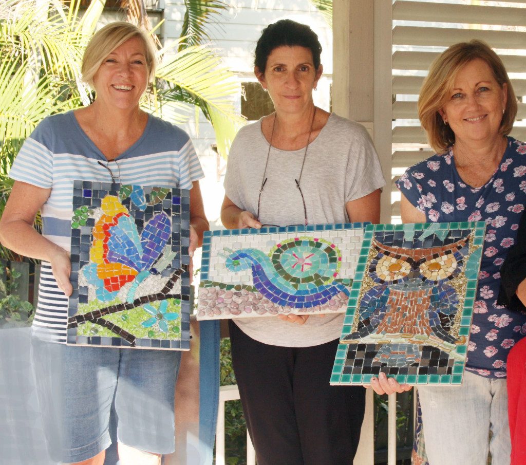 ladies holding mosaic artwork