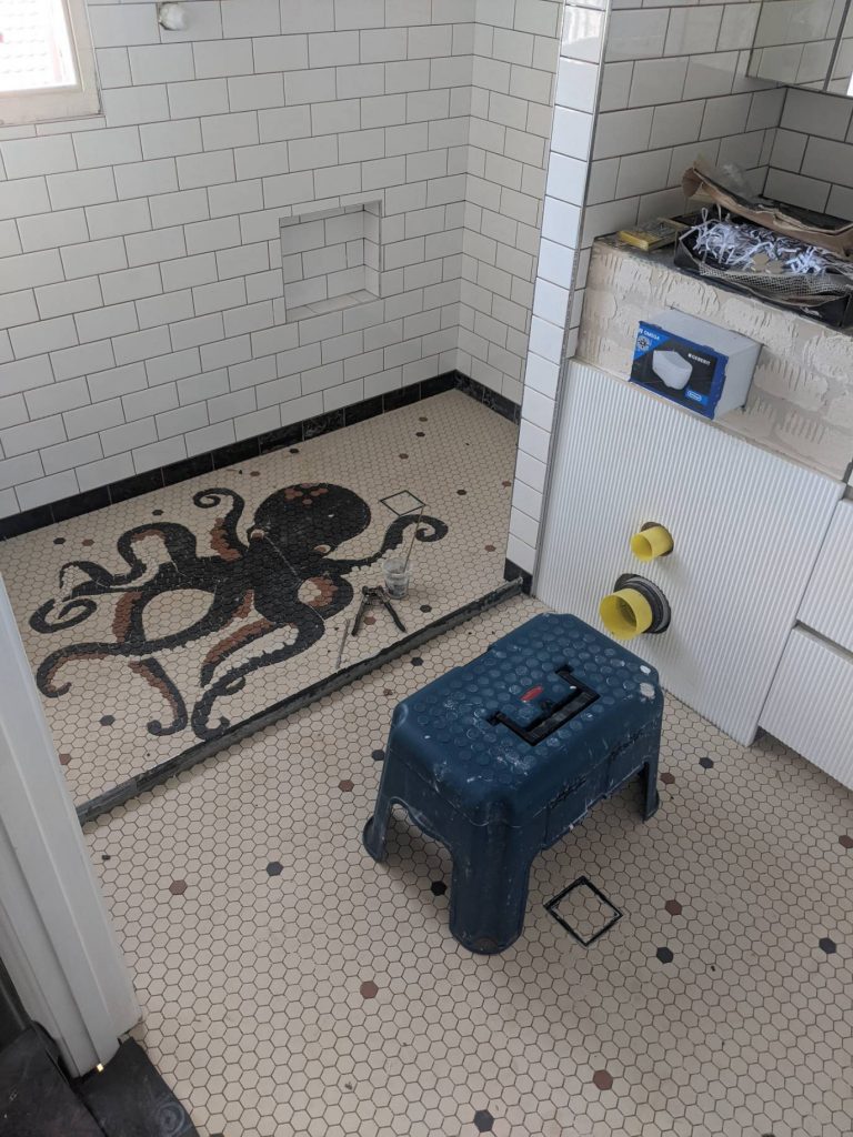 Octypus mosaic as a floor feature in a bathroom